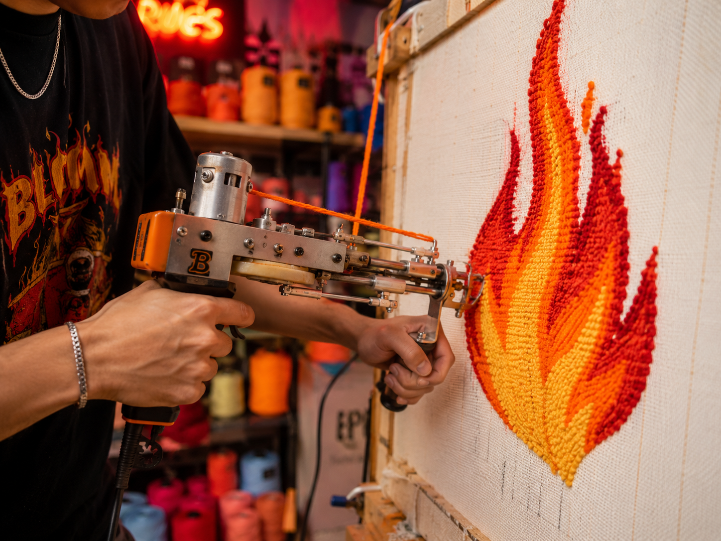 Persona utilizando una pistola de tufting para crear un diseño de llama